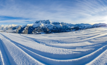 Ski tracks in snow and a mountain range