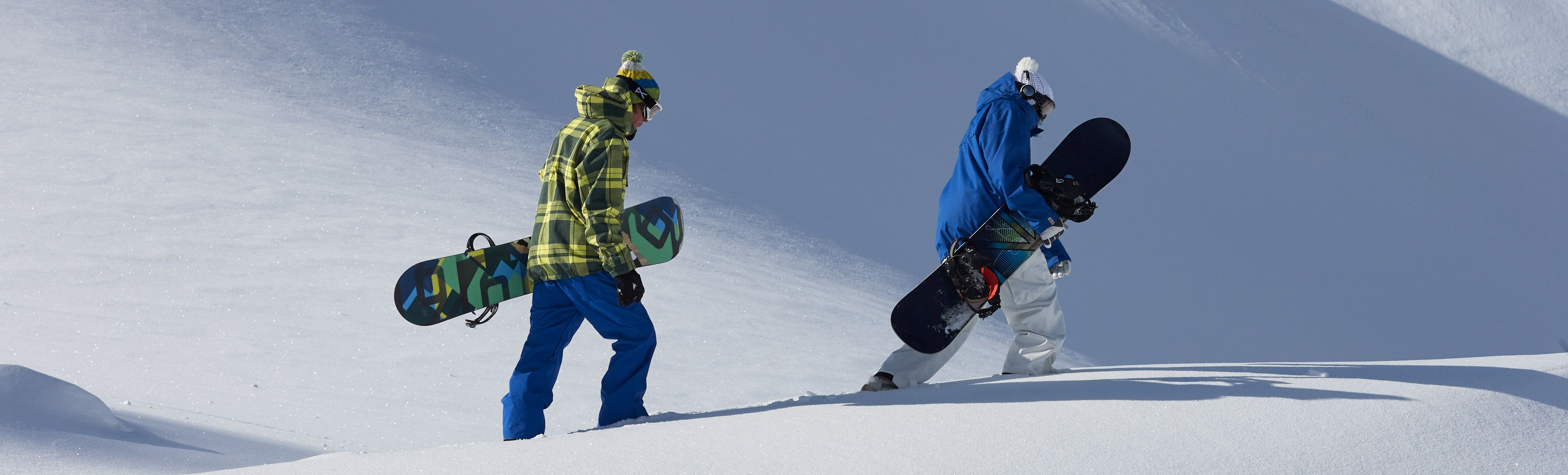 Two snowboards walking on virgin snow